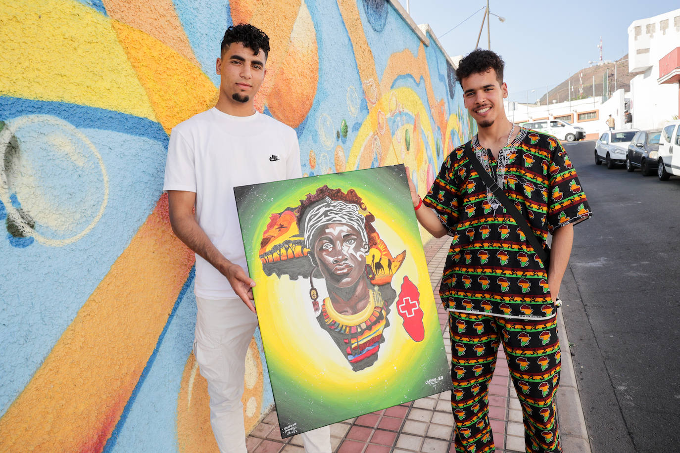 Abderazzak Arappâ (i) y Achraf Hafsaoui (d) posan con uno de los cuadros que pintaron a cuatro manos, durante su estancia en Canarias 50.
