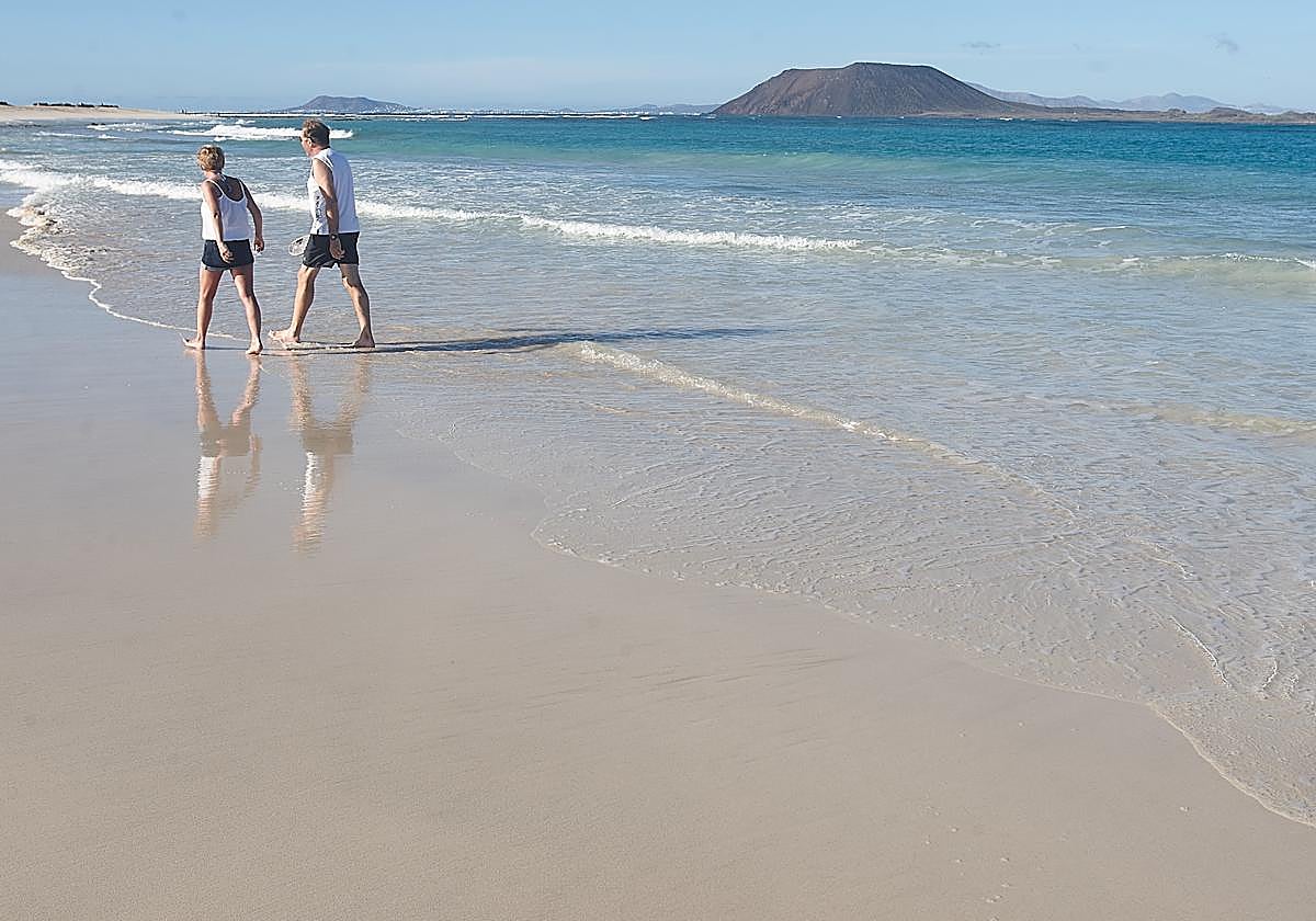 Dos turistas en las Grandes Playas de Corralejo, en el municipio de La Oliva.