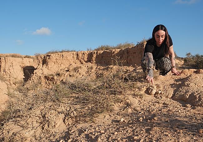 La fundadora de Amaifa señala algunos de los fósiles del barranco.