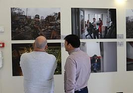 Dos personas observan las fotos de Maloletka en la Biblioteca Insular.