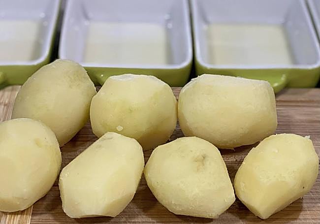 Pelamos las papas y engrasamos moldes