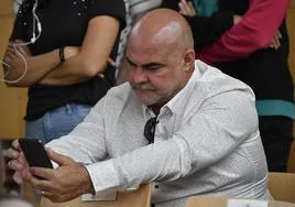 Marco Antonio Navarro Tacoronte, alias el Mediador, mira su móvil en un pleno del Cabildo tinerfeño.