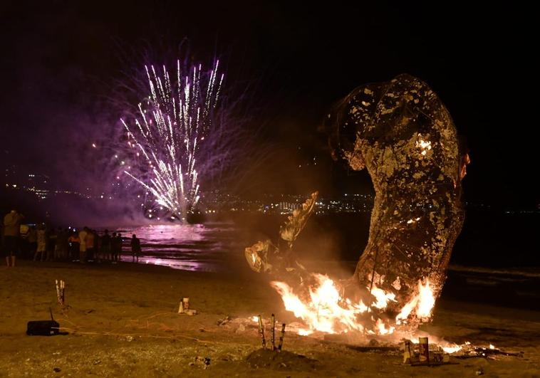 La sardina ardiendo en Playa del Inglés con los fuegos artificiales al fondo.