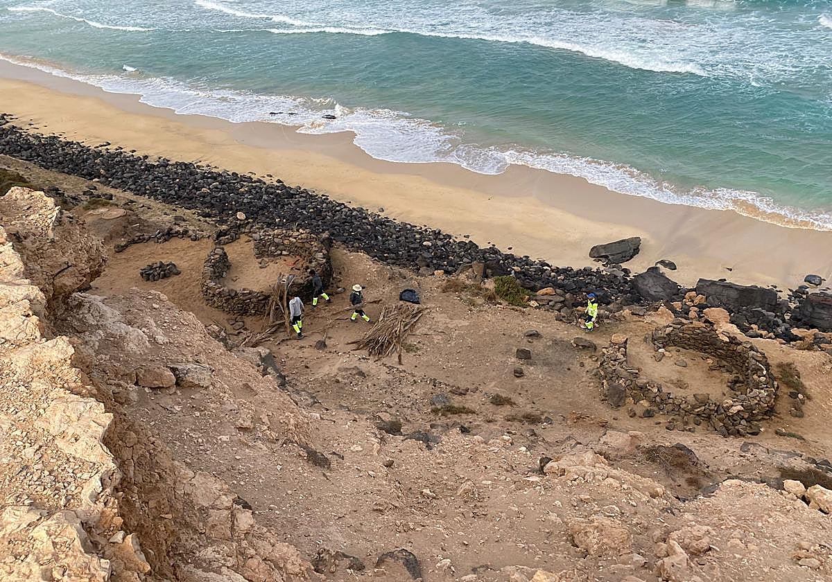 Tareas de retirada del techo de uno de los goros que una pareja usaba de vivienda en Piedra Playa.