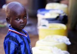 Un niño espera para comprar agua, en una fotografía de archivo del 15 de marzo de 2007 tomada en la localidad de Kibera, Kenya, el barrio de África con la infraestructura para abastecimiento de agua más precaria.