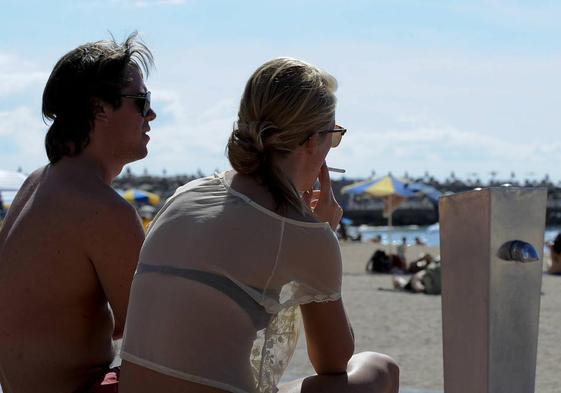 Imagen de archivo de una mujer fumando en la playa de Amadores.