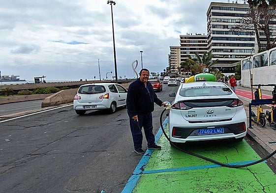 Luis Carlos Lorenzo carga su coche eléctrico junto a la Supercomisaría, en Las Palmas de Gran Canaria.