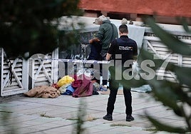 Otro hombre revisa las pertenencias del fallecido bajo supervisión policial.