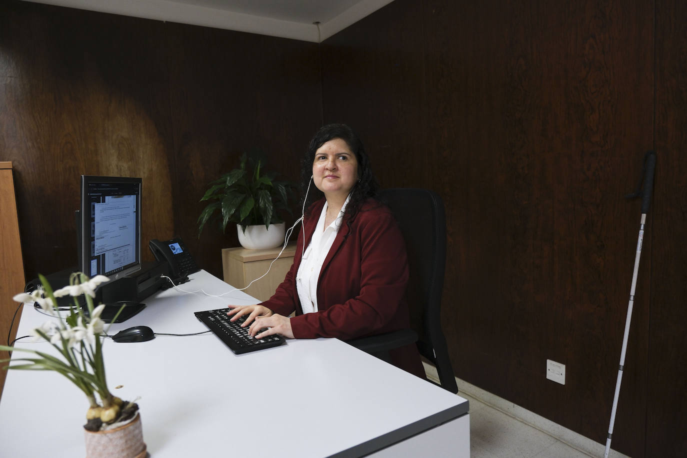 Mifaya en su puesto de trabajo en el Ayuntamiento de Telde, con su bastón guía a su lado como fiel compañero.