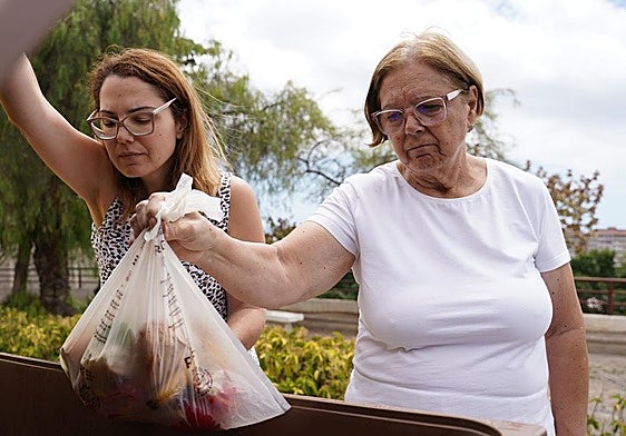 María Teresa Nuez y su hija Laura Delgado tirando residuos al quinto contenedor.