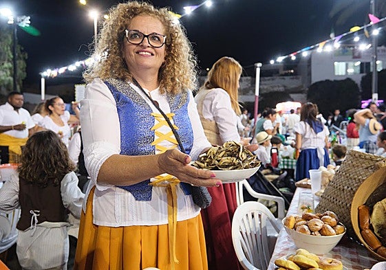 Mujer ataviada con ropa tradicional invita a un plato de pejines con cebolla en el Gran Baile de Taifas de este jueves por la noche en Puerto del Rosario.
