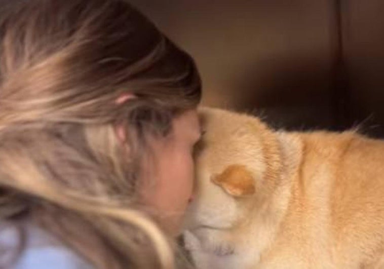 Astrid Klisans abrazando a Haru, la perrita de la familia.