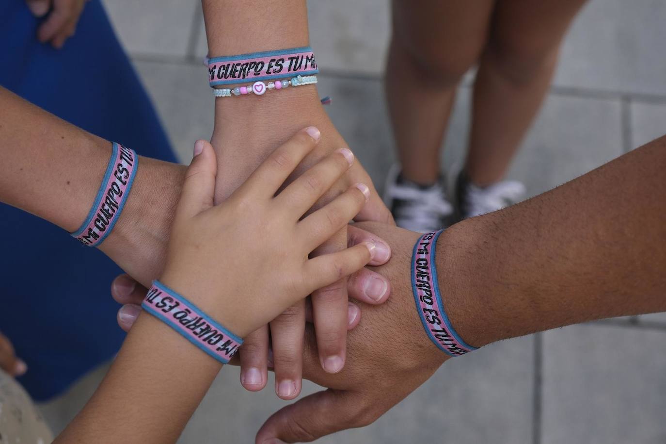 La familia luce estas pulseras con el los colores de la bandera trans.
