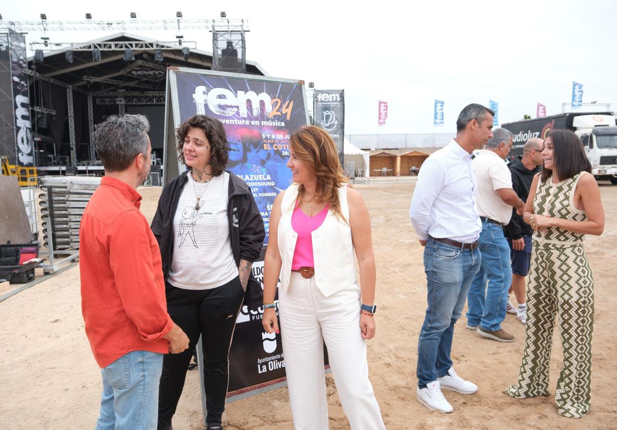 La presidenta Lola García departe con una artista del FEM en la Concha, la presentadora Mariam Hernández charla con el alcalde de La Oliva, Isaí Blanco.