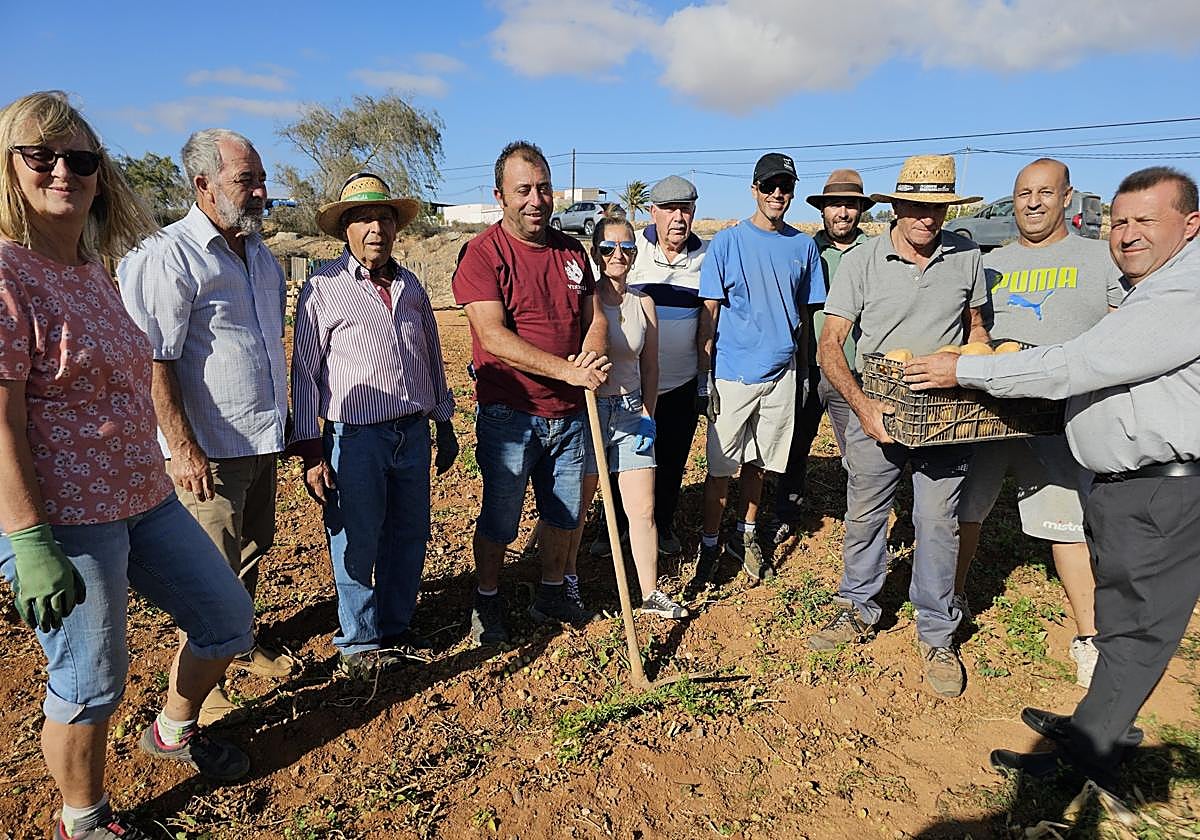 El alcalde Matías Peña entrega la caja de papas a Juan López, propietario de las gavias que cedió para los cursos.