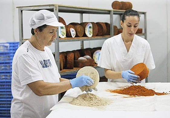 Nicolasa Castro Roger unta un queso de cabra con gofio, mientras su hija lo hace con pimentón, en la ganadería La Pared, en el municipio de Pájara.