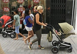 Foto de archivo de personas pasendocon bebés en Arrecife.