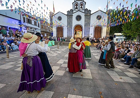 Un grupo en pleno baile delante de la fachada de la iglesia principal de Vallseco.