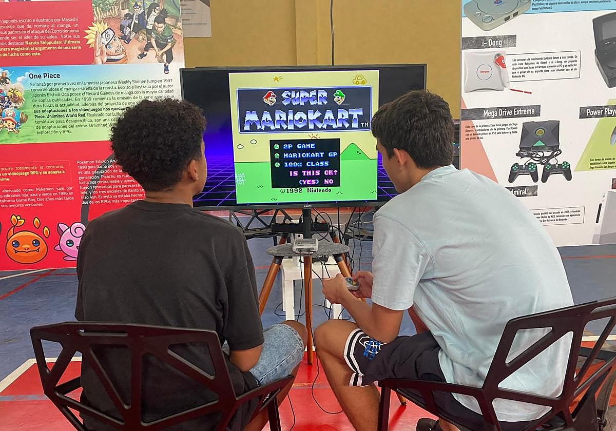 Dos jóvenes jugando en la zona de entretenimiento habilitada en el evento.
