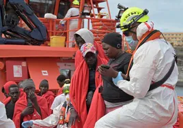 Salvamento ayuda a descender de la embarcación a los rescatados en una patera cerca de El Hierro en noviembre.