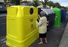 Una vecina de Las Palmas de Gran Canaria deposita envases en un contenedor.