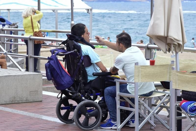 Imagen de archivo de una persona dependiente con su cuidador en el paseo de Las Canteras.
