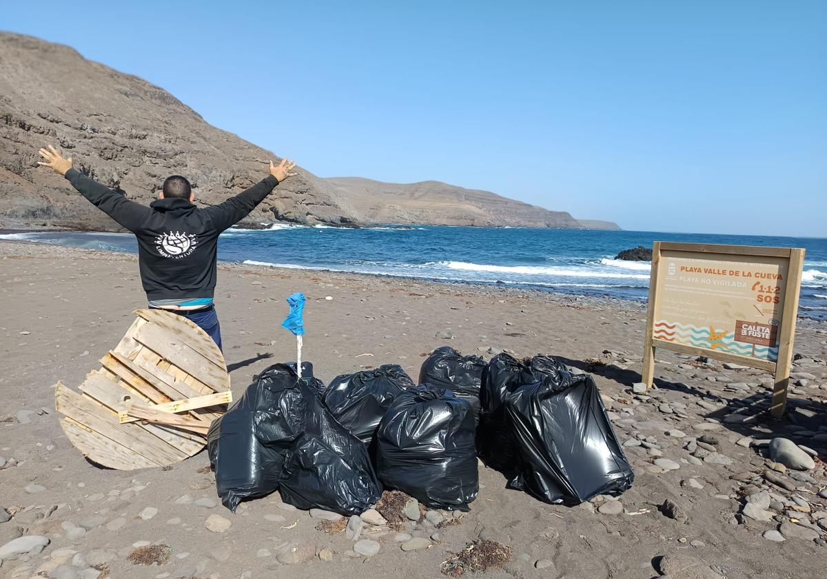 Un voluntario de Limpiaventura, con los sacos de basura recogida en las playas de Toneles y del Valle de la Cueva.