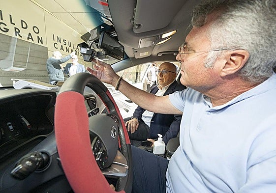 Un taxista enseña al presidente del Cabildo el funcionamiento de su cámara.