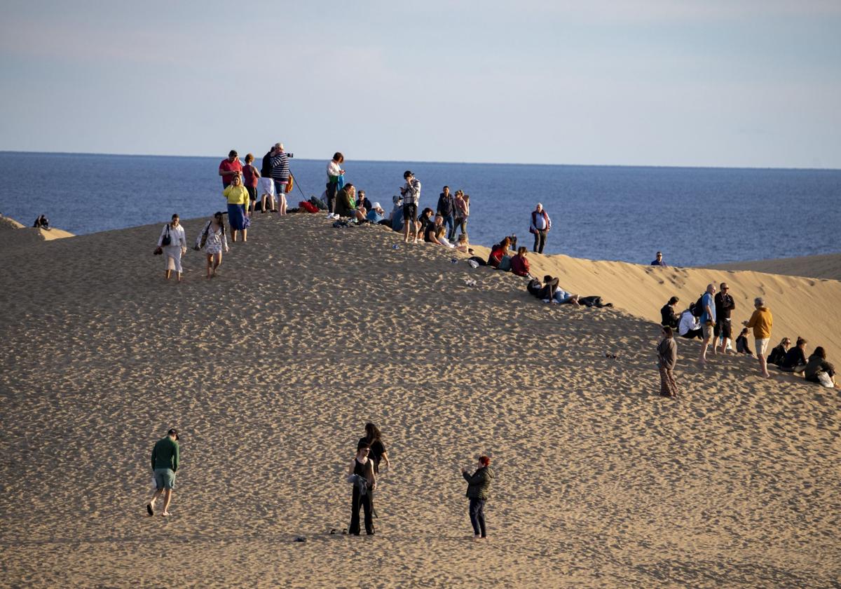 Turistas pasean y se retratan en las Dunas de Maspalomas.