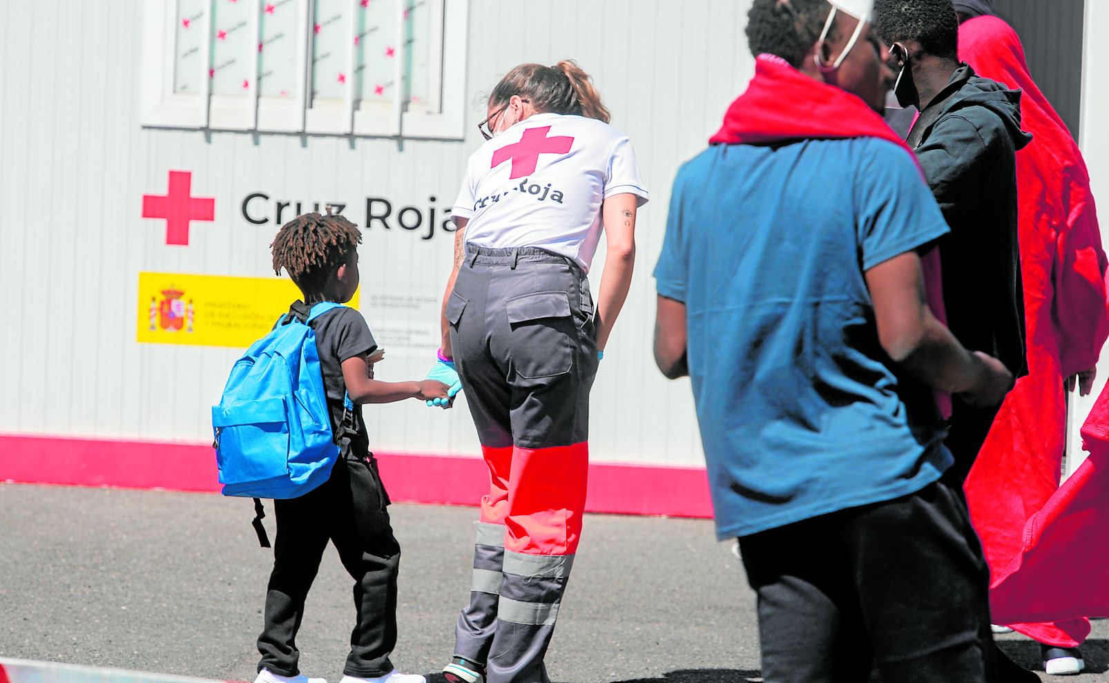 Un menor siendo atendido por una trabajadora de Cruz Roja en su llegada a Puerto del Rosario, Fuerteventura.