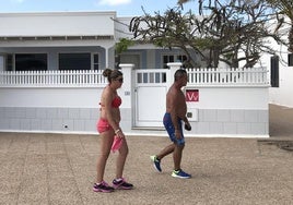 Dos turistas caminan por delante de una vivienda vacacional en la isla de Lanzarote.