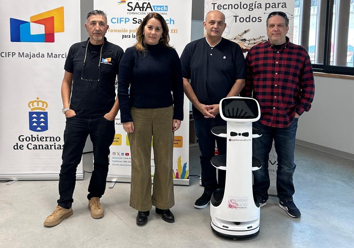 Lola García y Víctor Alonso, con los docentes del CIFP Majada Marcial, en Valladolid, con uno de los robots a construir.