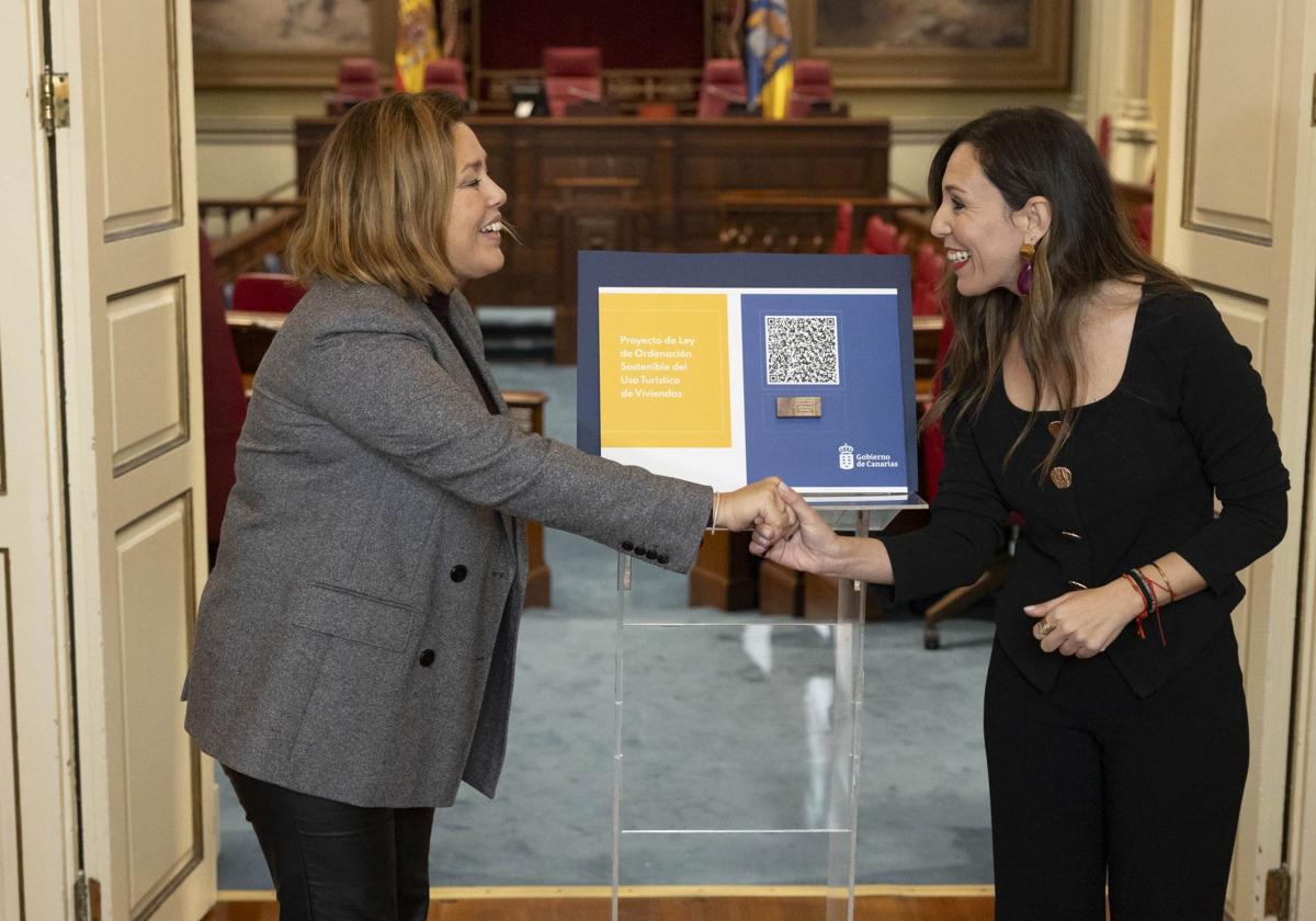 La consejera de Turismo y Empleo, Jessica de León (d) con la presidenta del Parlamento de Canarias, Astrid Pérez.