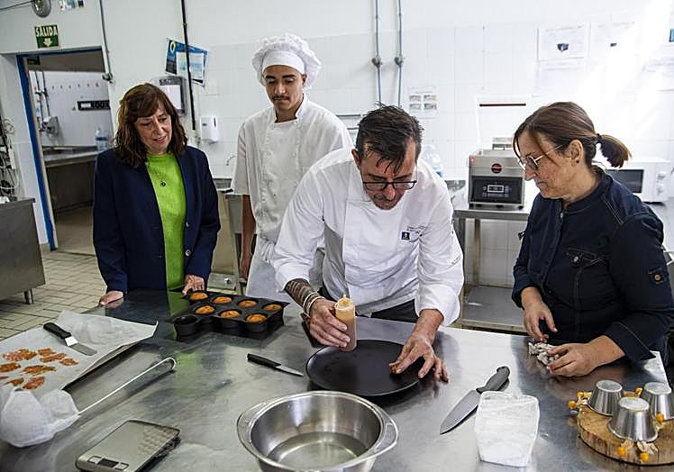 Carmelo Florido, del restaurante El equilibrista, ultima un postre junto a un alumno, la directora del centro, Rosa Delia Hernández, y Fuensanta Barrera.