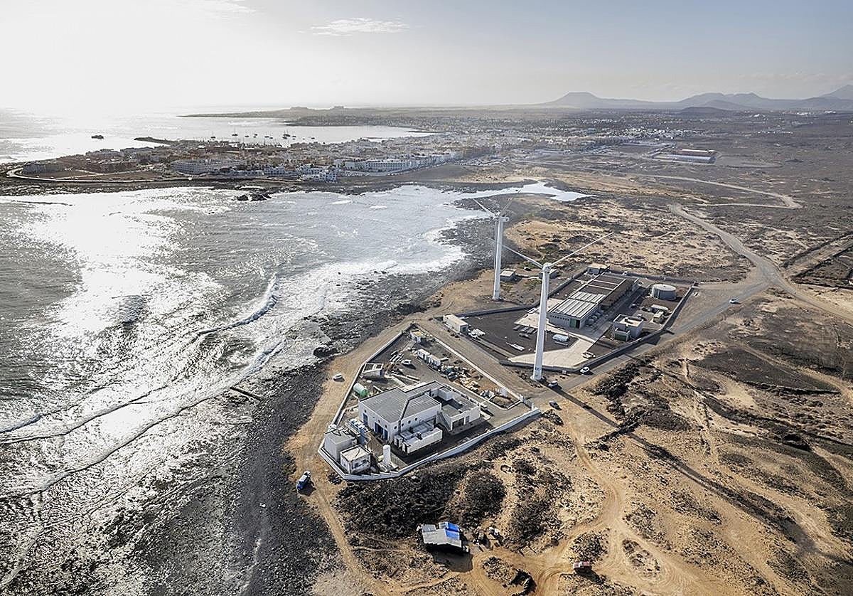 Vista aérea de la desaladora de Corralejo, con instalaciones energéticas y aerogeneradores
