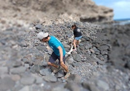 Dos voluntarios retiran un cabo de un barco en la costa de Antigua.