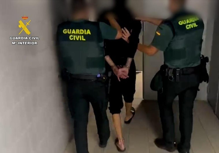 Imagen del hombre detenido por dos guardias.