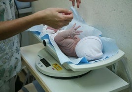 Foto de archivo de una enfermera pesando a un recién nacido en un hospital canario.