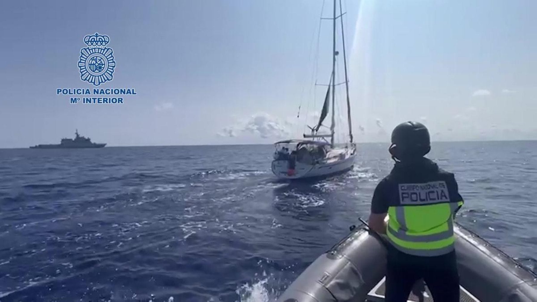 Imagen de un agente de la Policía Nacional durante el operativo, con el velero de fondo.