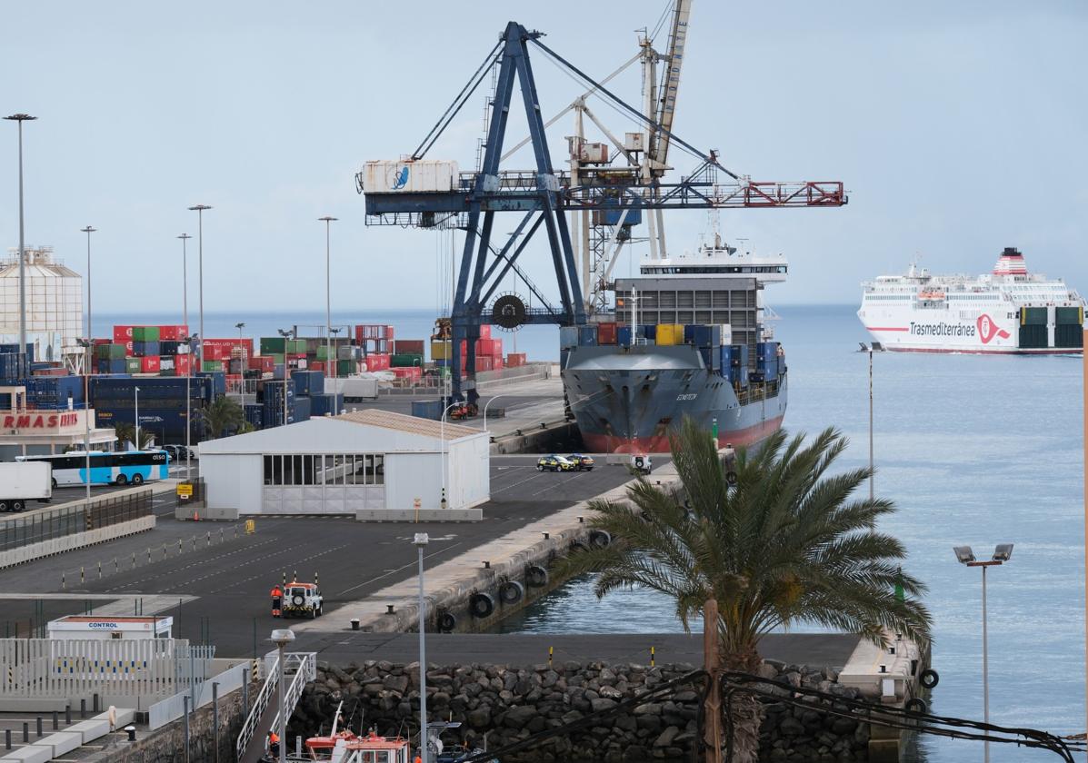 Un barco de contenedores atracado y el ferry de Armas-Trasmediterránea maniobrando para entrar en el puerto de la capital majorera.