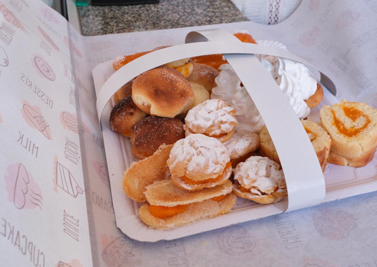 Imagen secundaria 1 - Con la gorra de Antoñito y sus mantecados, una bandeja variada de antoñitos y envolviendo más encargos.