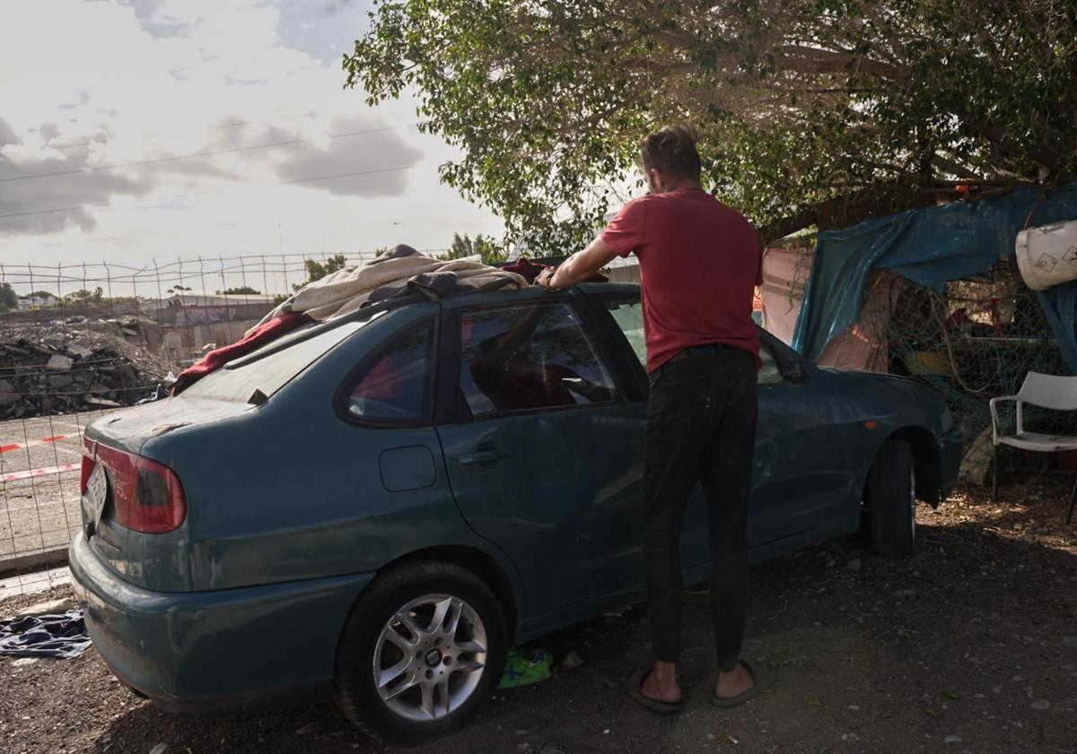 Imagen principal - En la imagen superior, José conserva su coche, aunque ya no arranca. Se lo presta como 'armario' a un vecino de poblado. Entre 12 y 14 personas sintecho han formado un núcleo de infraviviendas en San Fernando. 