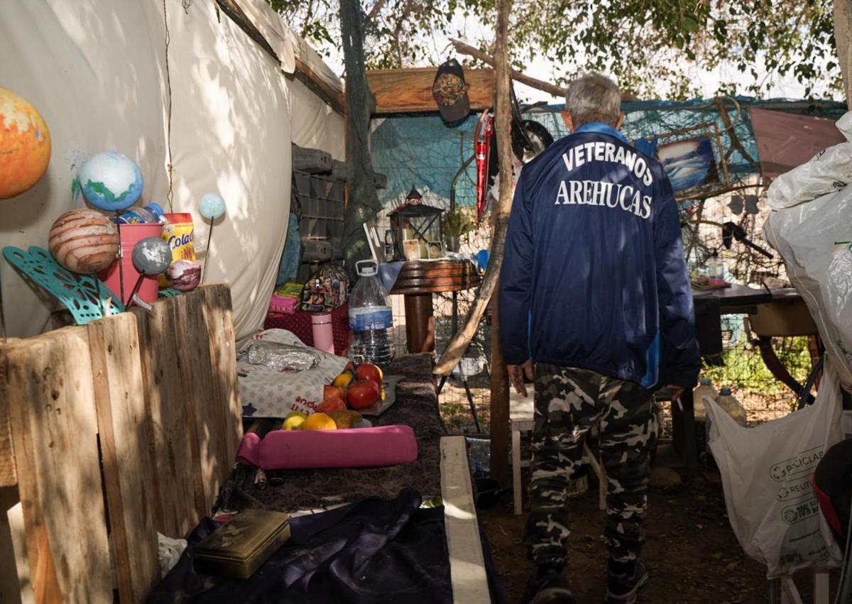 Imagen secundaria 1 - Massiga, sentado, junto a su pequeña chabola. Debajo, dos escenas del interior de la infravivienda de José y Aisha. Ellos duermen en un segundo piso, bajo un árbol (a la derecha, escalera de acceso). 