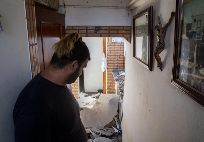 David Martínez, junto a la cocina de su casa, con el techo en el suelo.