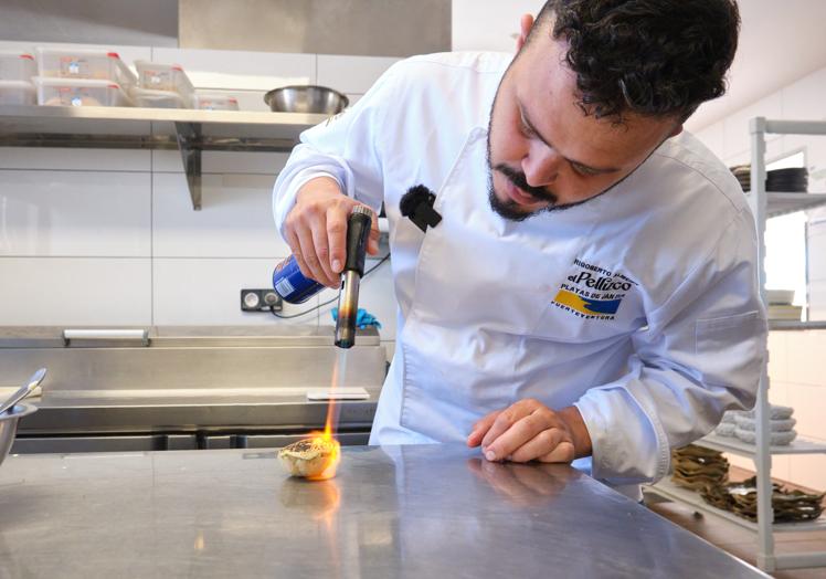El chef canario-cubano da el toque final con el soplete al crujiente de atún fresco para el plato de ventresca de atún rojo flambeados, puntos de salsa teriyaki, puntos de tuno indio, caviar oscietra y sal de espuma.