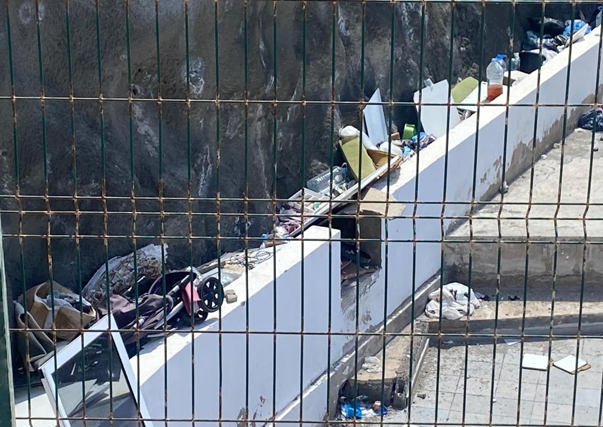 Imagen secundaria 1 - Basura acumulada en los exteriores y dentro del complejo. En la foto vertical, tapias levantadas en la conexión de los apartamentos con las terrazas.