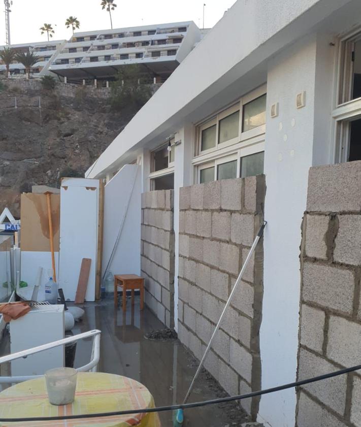 Imagen secundaria 2 - Basura acumulada en los exteriores y dentro del complejo. En la foto vertical, tapias levantadas en la conexión de los apartamentos con las terrazas.