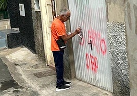 El acusado limpia en su casa una pintada en la que se llamaba asesino.