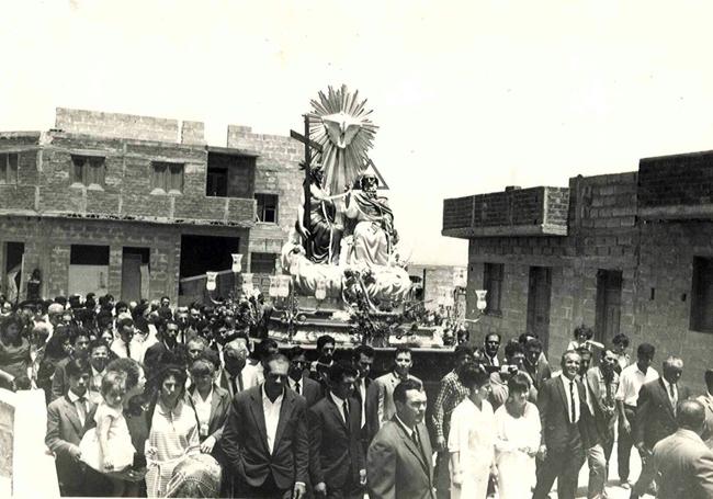Una procesión de la Santísima Trinidad por un barrio de El Tablero aún a medio crecer.