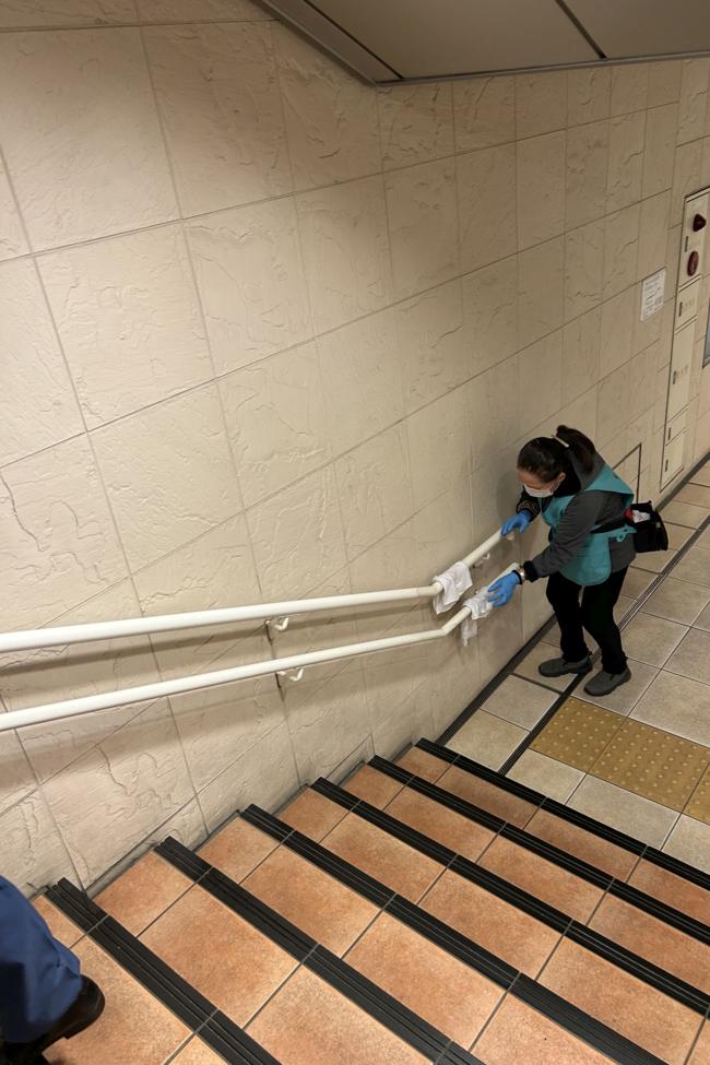 Una plantilla de señoras limpia los pasamanos en las estaciones de ferrocarril y metro